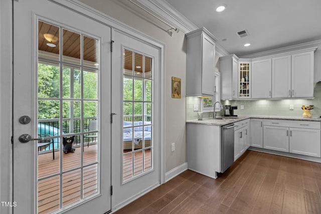 kitchen featuring a sink, stainless steel dishwasher, decorative backsplash, glass insert cabinets, and recessed lighting