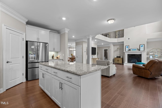 kitchen with stainless steel fridge, crown molding, white cabinetry, a center island, and open floor plan
