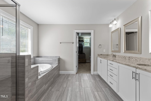 bathroom featuring a garden tub, double vanity, baseboards, an enclosed shower, and a spacious closet