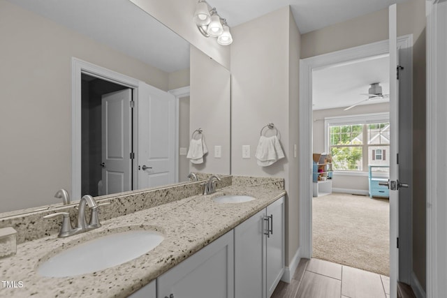 full bathroom featuring double vanity, a ceiling fan, and baseboards