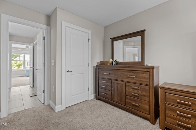 hall featuring light colored carpet and baseboards