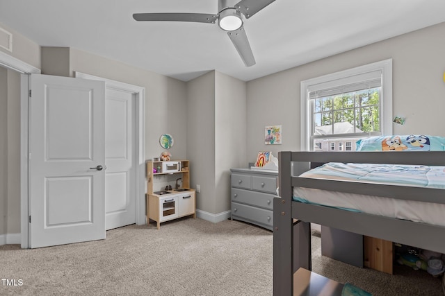 bedroom featuring light colored carpet, a ceiling fan, and baseboards