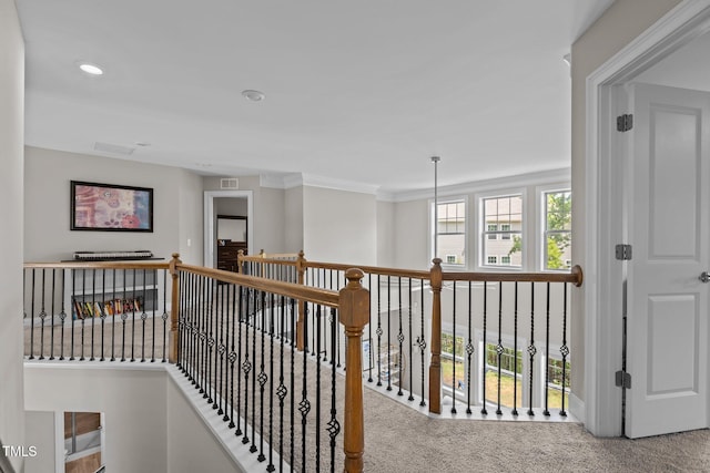 hallway featuring carpet, ornamental molding, an upstairs landing, and recessed lighting
