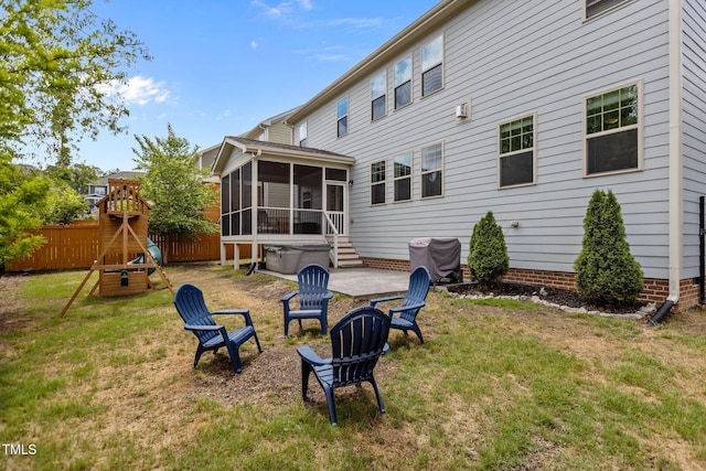 back of house featuring a sunroom, a hot tub, a patio, and a playground