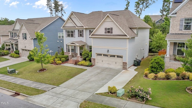 craftsman-style home with an attached garage, driveway, a front lawn, and roof with shingles