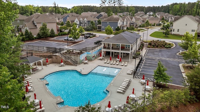 community pool with a residential view, stairway, and a patio area