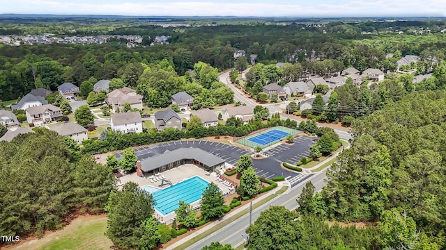 aerial view of a pool and a heavily wooded area