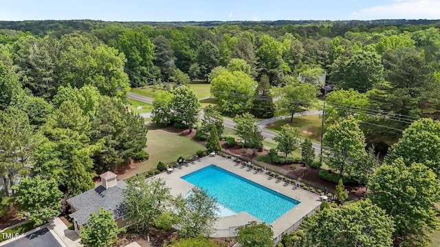 bird's eye view of a heavily wooded area and a pool