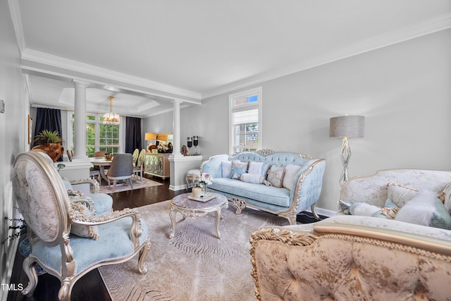 living room with decorative columns, crown molding, wood finished floors, and baseboards