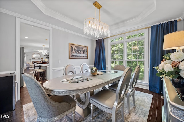 dining space featuring a chandelier, dark wood finished floors, crown molding, and a raised ceiling