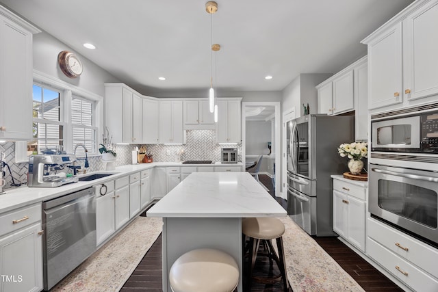 kitchen featuring appliances with stainless steel finishes, a sink, recessed lighting, decorative backsplash, and white cabinets