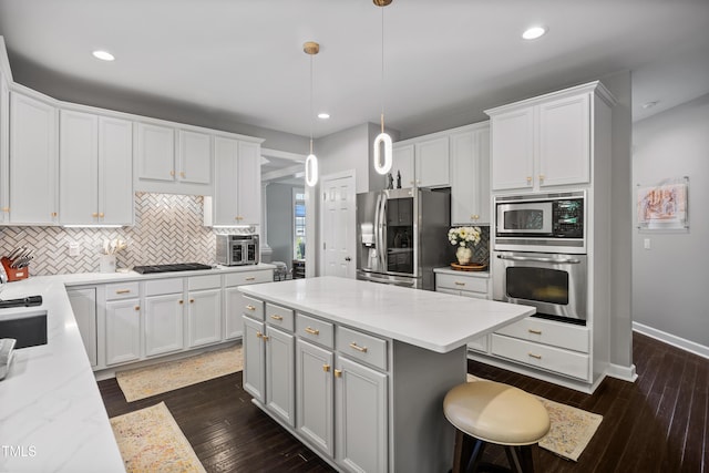 kitchen featuring stainless steel appliances, tasteful backsplash, white cabinetry, and recessed lighting