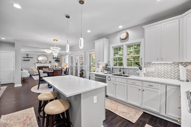kitchen with a sink, recessed lighting, a center island, tasteful backsplash, and white cabinets