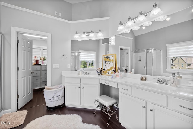 bathroom featuring a shower stall, wood finished floors, double vanity, and lofted ceiling