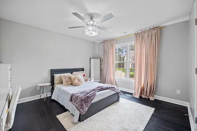 bedroom featuring baseboards, dark wood-style flooring, and a ceiling fan