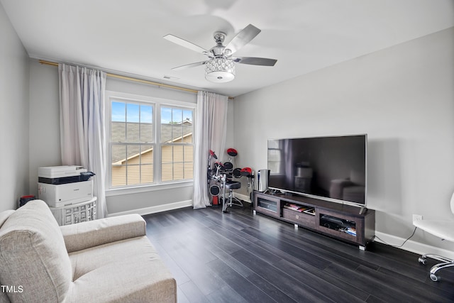living area featuring wood finished floors, ceiling fan, and baseboards