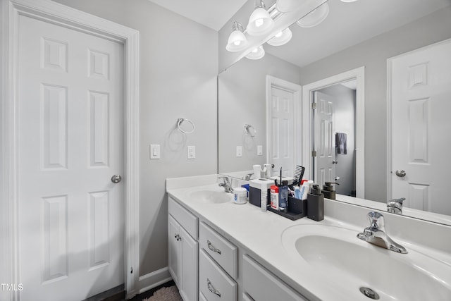 bathroom with double vanity and baseboards