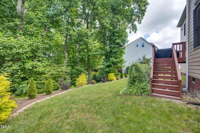 view of grassy yard with stairs and a wooden deck