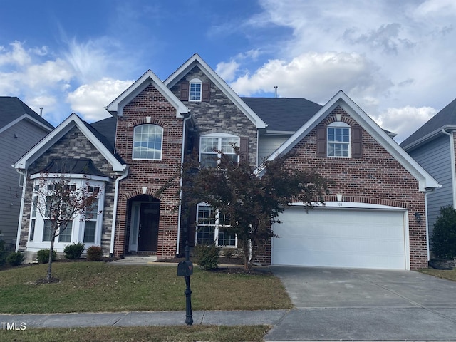 traditional home featuring concrete driveway, a front yard, a garage, brick siding, and stone siding