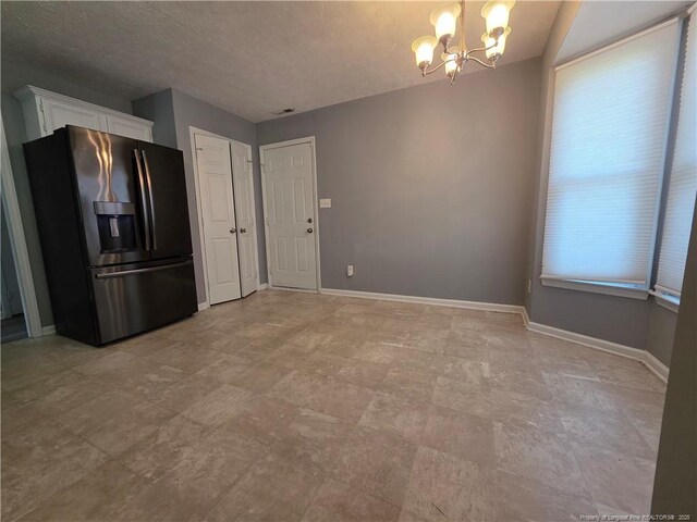 2604 Burke Ln, Fayetteville, NC 28306 - unfurnished dining area with a chandelier, baseboards, and a textured ceiling