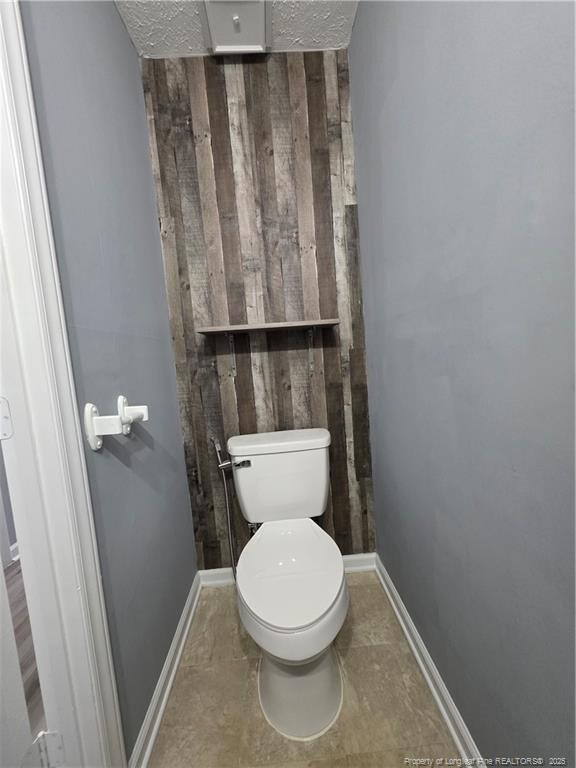 2604 Burke Ln, Fayetteville, NC 28306 - bathroom with toilet, wooden walls, and baseboards