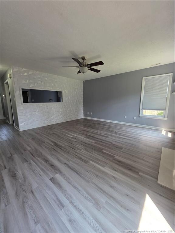 2604 Burke Ln, Fayetteville, NC 28306 - unfurnished living room with a ceiling fan, wood finished floors, and baseboards