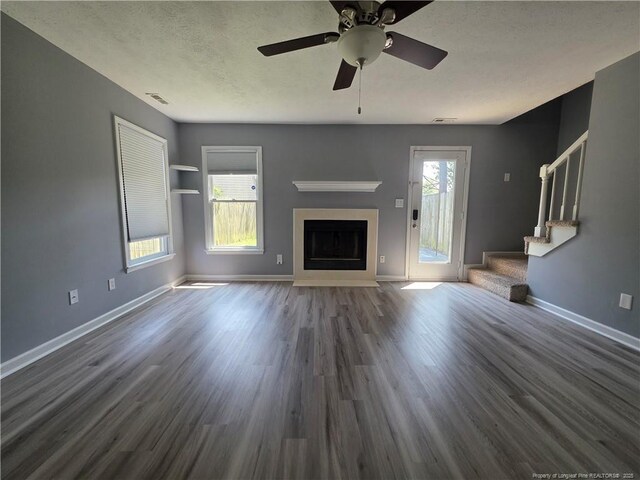 2604 Burke Ln, Fayetteville, NC 28306 - unfurnished living room with stairs, baseboards, wood finished floors, and a textured ceiling