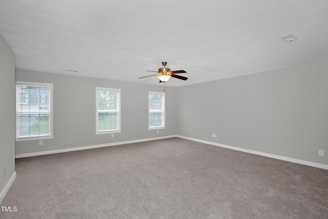 empty room with carpet flooring, baseboards, and ceiling fan