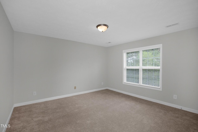 empty room featuring carpet floors and baseboards