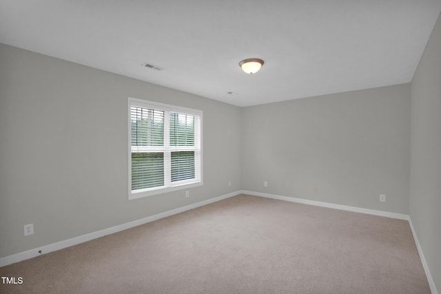 empty room featuring carpet flooring and baseboards