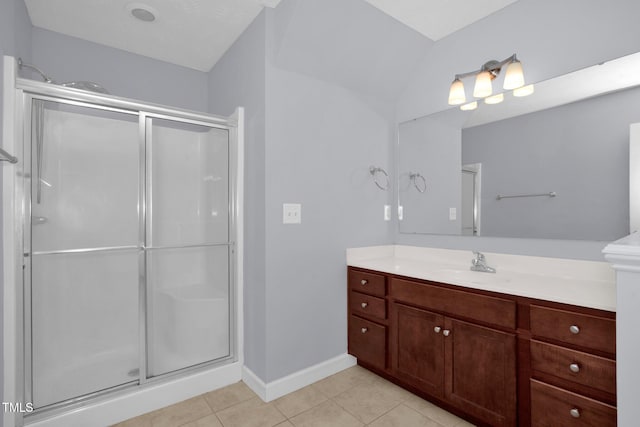 bathroom with tile patterned floors, a stall shower, vanity, and baseboards