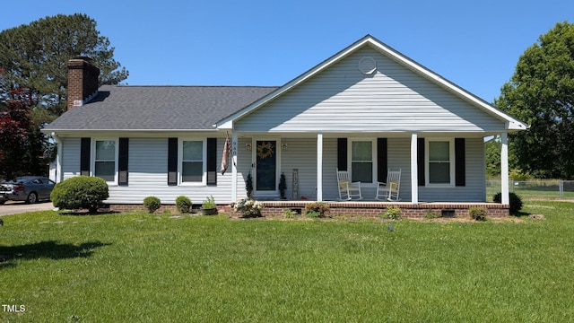 view of front facade with covered porch, a chimney, a front lawn, a shingled roof, and crawl space