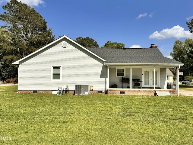 back of property featuring crawl space, central air condition unit, a lawn, a chimney, and roof with shingles