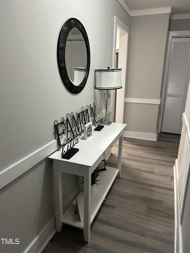 office space with wood finished floors, baseboards, and crown molding
