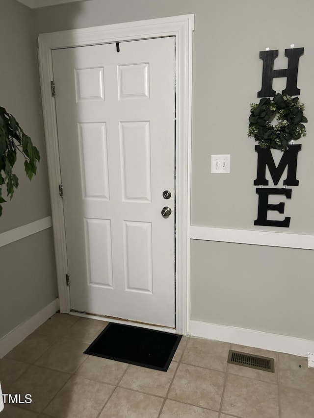 entryway with tile patterned flooring and baseboards