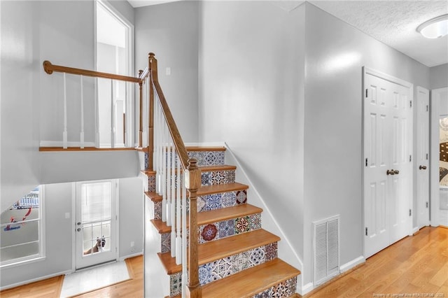 4725 Grandison Ct, Hope Mills, NC 28348 - staircase with wood finished floors, baseboards, and a textured ceiling