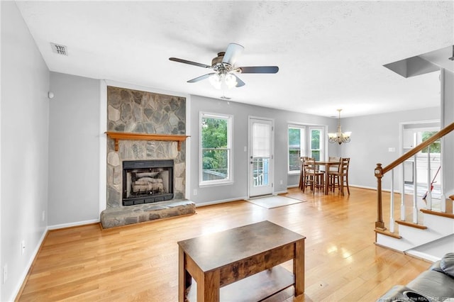 4725 Grandison Ct, Hope Mills, NC 28348 - living area with light wood finished floors, stairs, a fireplace, ceiling fan, and a chandelier