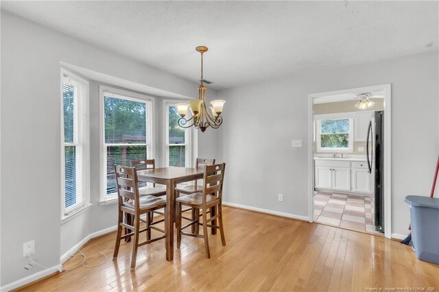 4725 Grandison Ct, Hope Mills, NC 28348 - dining room featuring a chandelier, light wood-style flooring, and baseboards