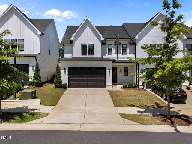 modern farmhouse style home featuring board and batten siding, a garage, concrete driveway, a front lawn, and a shingled roof