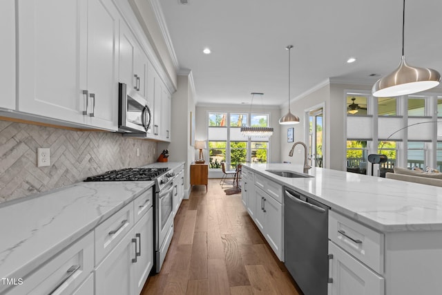kitchen featuring a sink, stainless steel appliances, ornamental molding, dark wood-style flooring, and white cabinets
