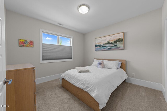 bedroom featuring light colored carpet and baseboards