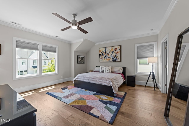 bedroom featuring ornamental molding, wood finished floors, multiple windows, and baseboards