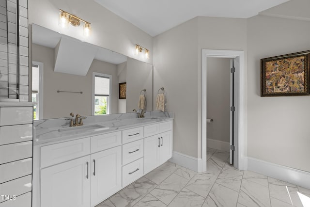 full bath featuring marble finish floors, double vanity, and baseboards