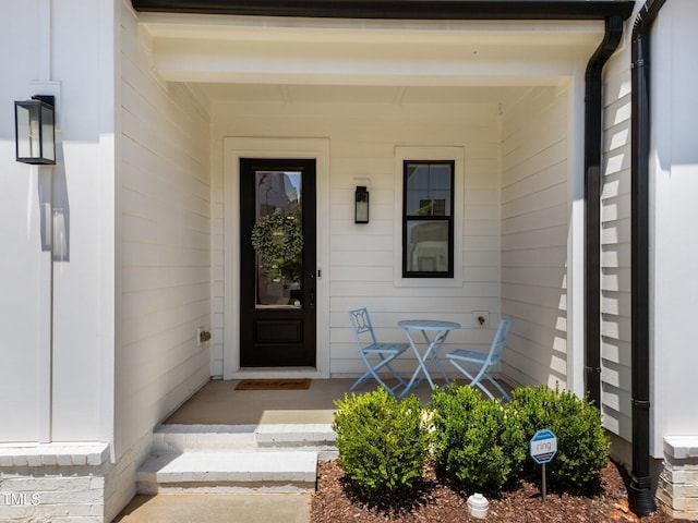view of exterior entry featuring covered porch