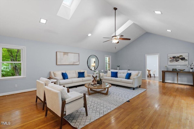 3418 Carriage Trl, Hillsborough, NC 27278 - living room featuring light wood-style floors, lofted ceiling, a skylight, a ceiling fan, and baseboards