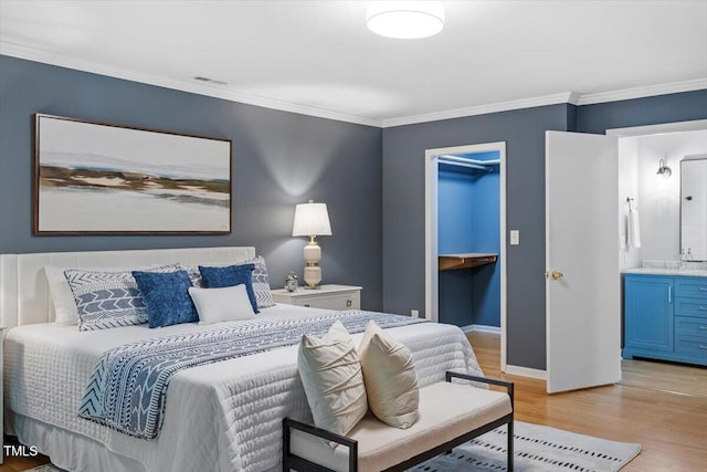 3418 Carriage Trl, Hillsborough, NC 27278 - bedroom featuring light wood-style flooring, ornamental molding, baseboards, ensuite bathroom, and a walk in closet