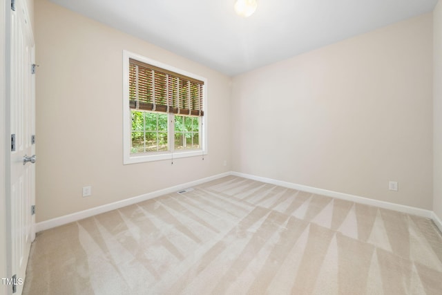 unfurnished room with baseboards and light carpet