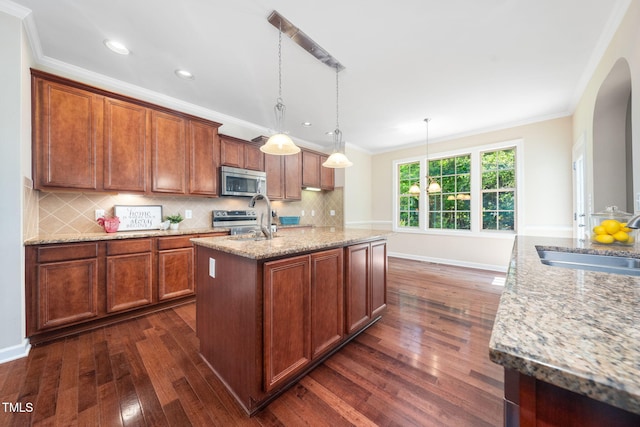 kitchen with stainless steel appliances, a sink, dark wood finished floors, crown molding, and backsplash