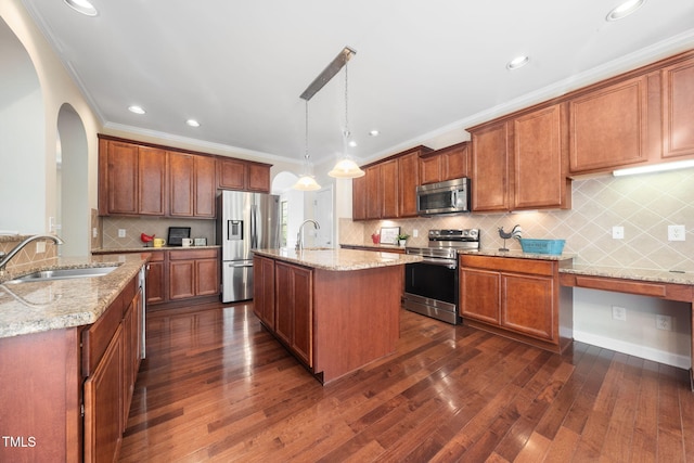 kitchen featuring appliances with stainless steel finishes, a sink, dark wood-type flooring, light stone countertops, and arched walkways
