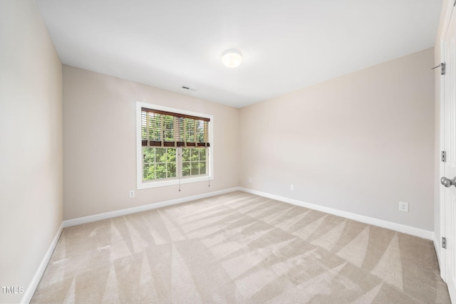 empty room with light colored carpet and baseboards